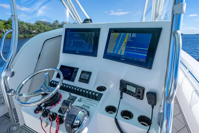 Slide: The Image of 2019 Contender 39 Fisharound boat dashboard with navigation screens and controls. - 18