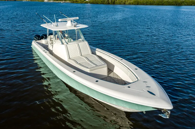 Slide: The Image of 2019 Contender 39 Fisharound boat on calm water, featuring sleek design and spacious deck. - 25