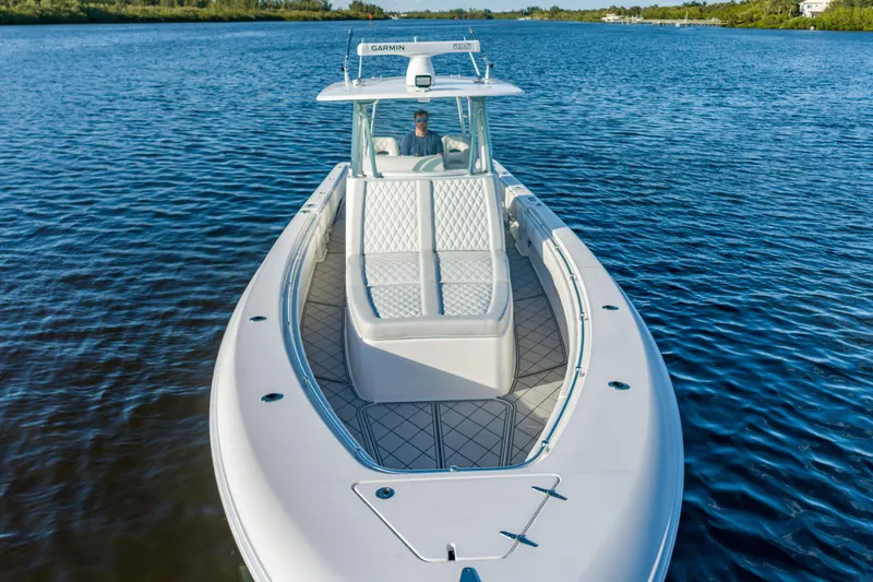 Slide: The Image of 2019 Contender 39 Fisharound boat cruising on a calm lake with lush shoreline. - 26