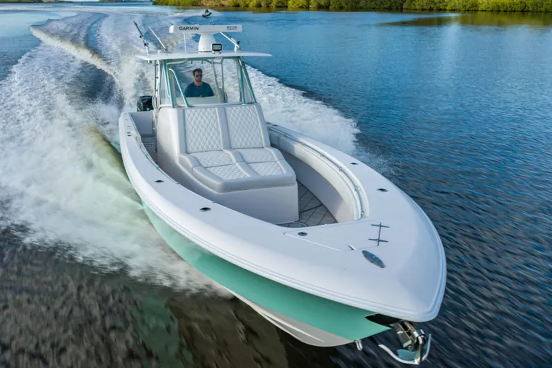 Slide: The Image of 2019 Contender 39 Fisharound cruising on a serene waterway, showcasing sleek design and performance. - 29