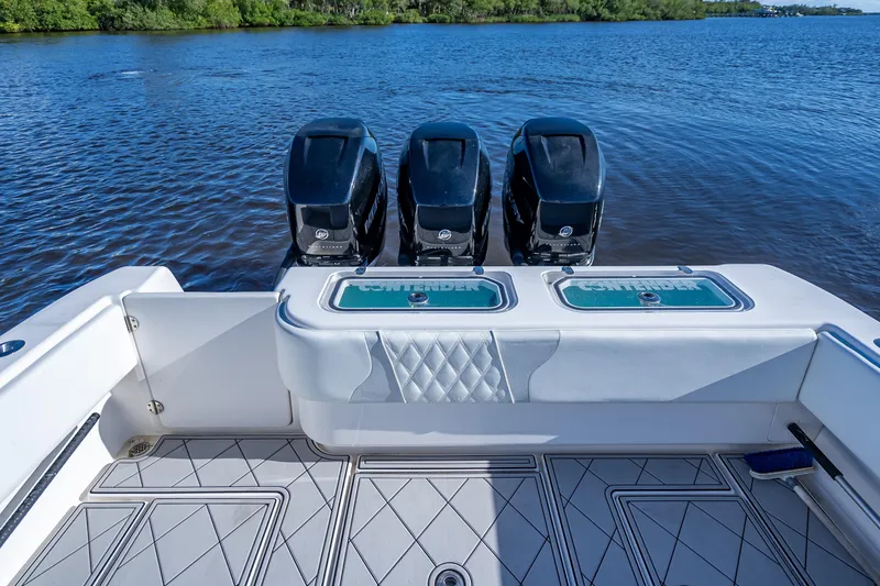 Slide: The Image of 2019 Contender 39 Fisharound boat with triple outboard engines on a calm lake. - 31