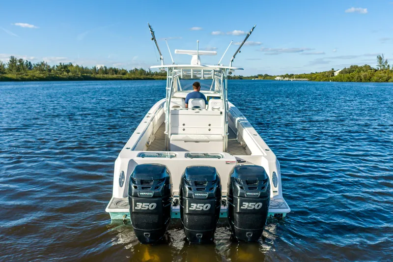 Slide: The Image of 2019 Contender 39 Fisharound boat with triple 350 Verado engines on a calm waterway. - 5