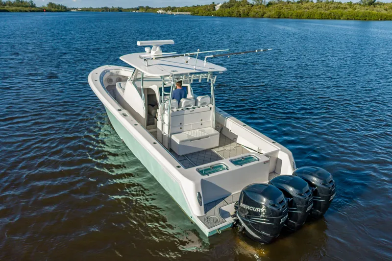 Slide: The Image of 2019 Contender 39 Fisharound boat with triple Mercury engines on calm water. - 8