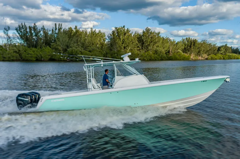 Slide: The Image of 2019 Contender 39 Fisharound boat cruising on a scenic river under a cloudy sky. - 9