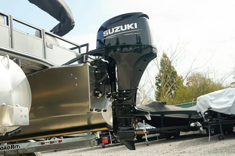 Slide: The Image of Dockside 20DQ 2026 boat with Suzuki outboard motor, parked on a trailer. - 13