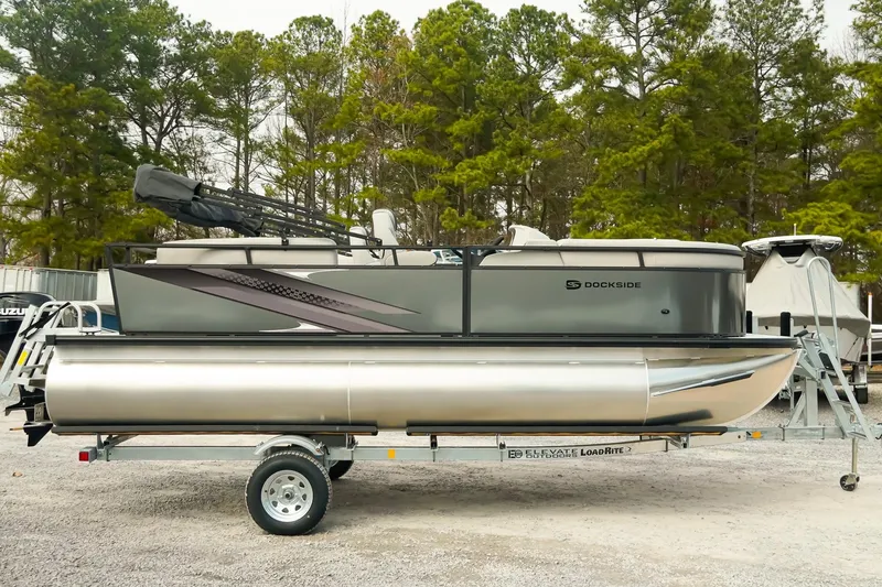 Slide: The Image of 2026 Dockside 20DQ pontoon boat on trailer, surrounded by trees. - 3