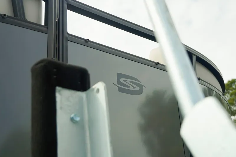 Slide: The Image of Close-up of 2026 Dockside 20DQ boat exterior with logo and railing. - 38