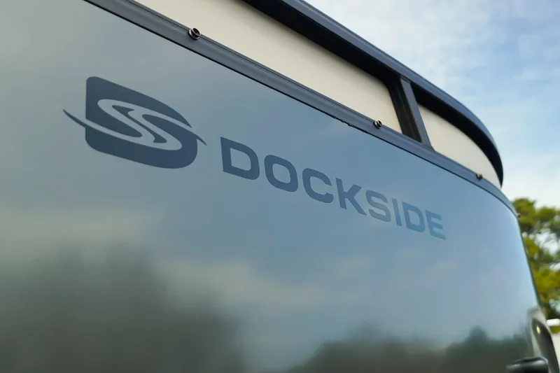 Slide: The Image of 2026 Dockside 20DQ boat exterior with logo against a clear sky. - 41