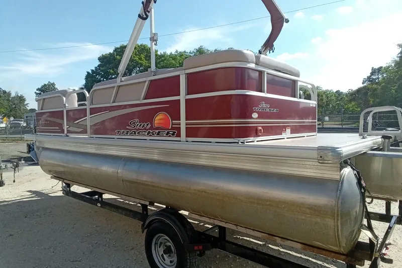 Slide: The Image of 2014 Sun Tracker Party Barge 20 DLX pontoon boat on trailer, parked outdoors. - 12