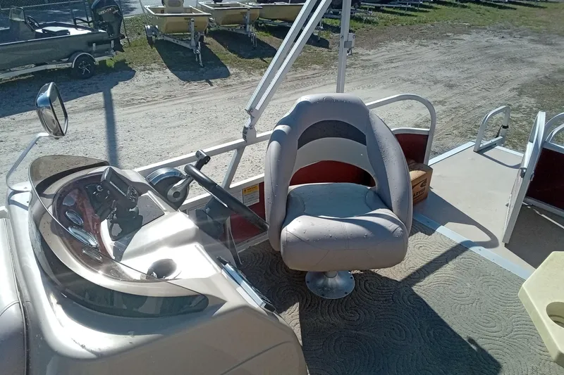 Slide: The Image of 2014 Sun Tracker Party Barge 20 DLX interior with captain's chair and steering console. - 7
