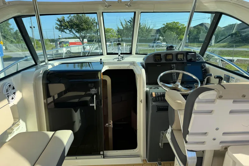 Slide: The Image of 2007 Pursuit OS 335 Offshore boat cockpit with steering wheel and navigation equipment. - 11