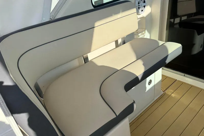 Slide: The Image of 2007 Pursuit OS 335 Offshore boat interior seating with beige upholstery and wood flooring. - 12