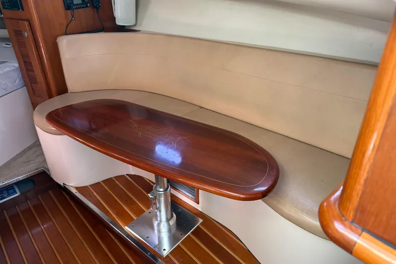 Slide: The Image of 2007 Pursuit OS 335 Offshore cabin with wooden table and beige seating. - 14