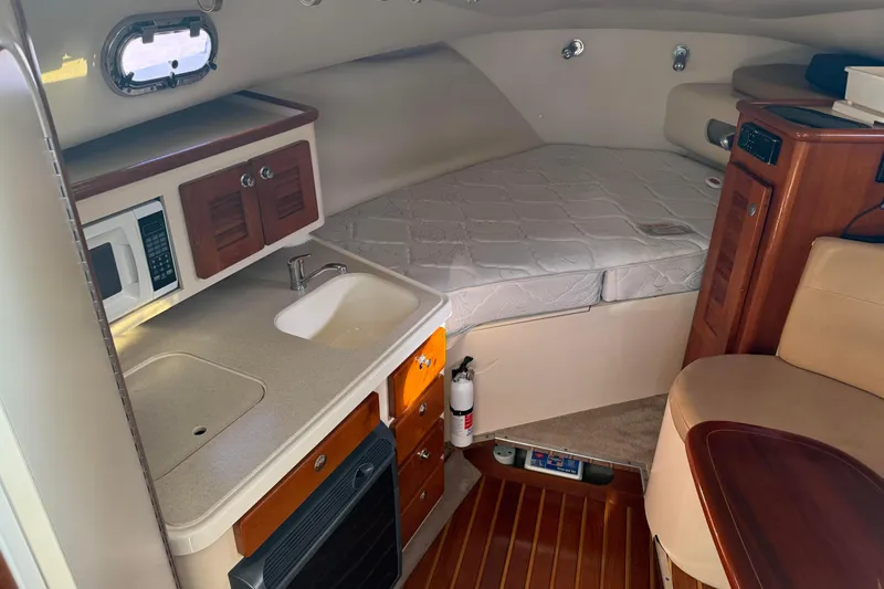 Slide: The Image of 2007 Pursuit OS 335 Offshore cabin interior with kitchenette and bed. - 15