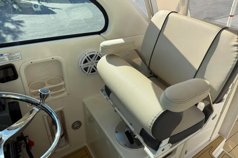 Slide: The Image of Captain's chair and helm of 2007 Pursuit OS 335 Offshore boat, featuring steering wheel and speaker. - 17
