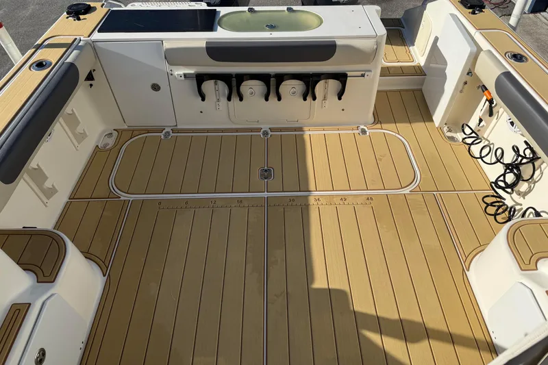 Slide: The Image of 2007 Pursuit OS 335 Offshore boat deck with teak flooring and fishing rod holders. - 20