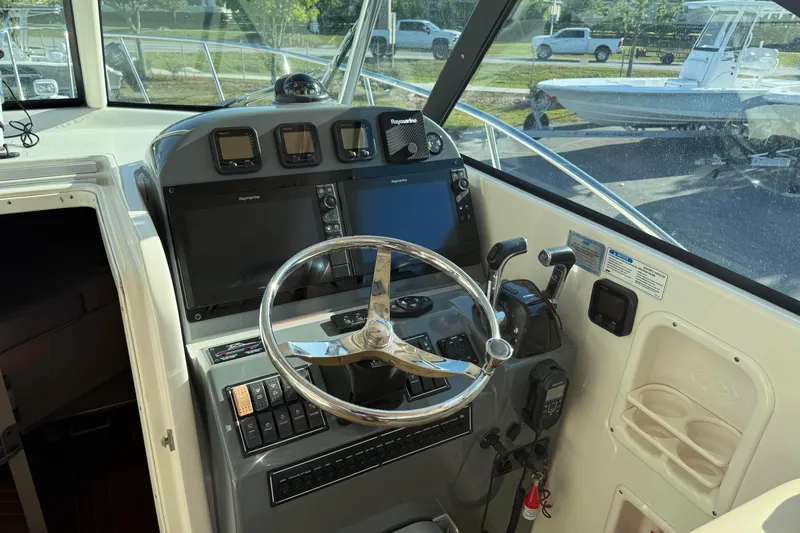 Slide: The Image of Helm of 2007 Pursuit OS 335 Offshore boat with steering wheel and navigation controls. - 21