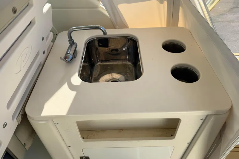 Slide: The Image of 2007 Pursuit OS 335 Offshore boat sink with faucet and cup holders. - 22