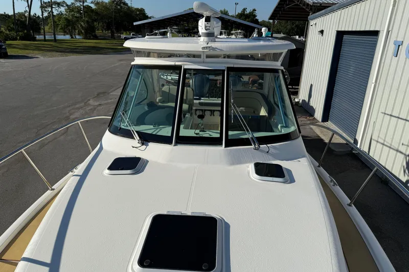 Slide: The Image of 2007 Pursuit OS 335 Offshore boat docked, showcasing sleek design and spacious deck. - 24