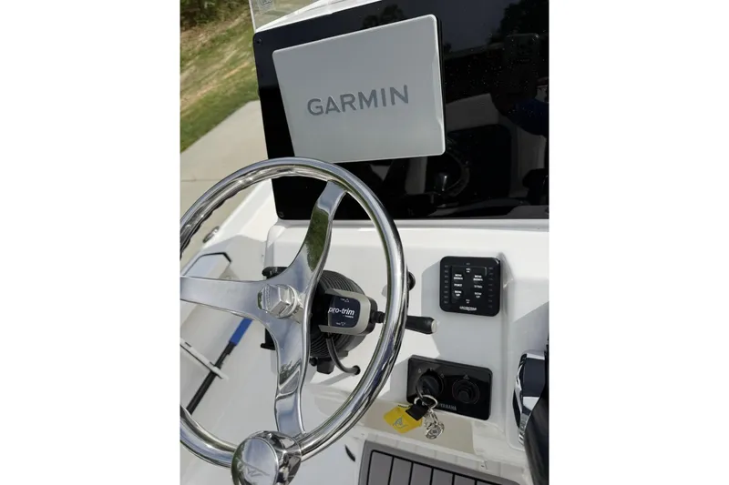 The Image of 2024 Tidewater 2110 Bay Max boat dashboard with Garmin navigation system and steering wheel. - 2