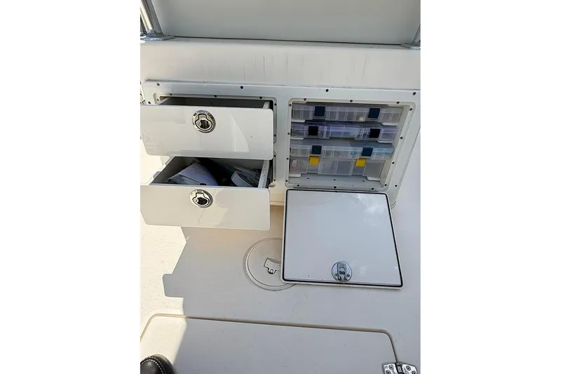Slide: The Image of Storage compartments on a 2020 Pathfinder 2500 Hybrid boat, featuring drawers and tackle boxes. - 13