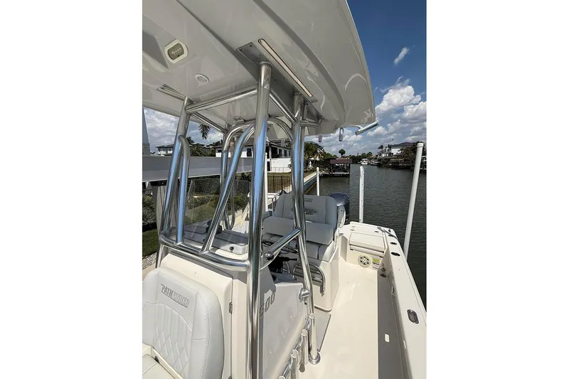 Slide: The Image of 2020 Pathfinder 2500 Hybrid boat interior with seating and chrome details, docked by waterfront homes. - 22