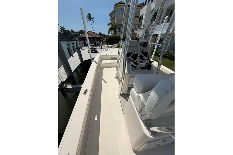 Slide: The Image of 2020 Pathfinder 2500 Hybrid boat docked, featuring a sleek console and comfortable seating. - 25