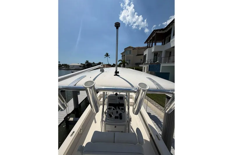Slide: The Image of 2020 Pathfinder 2500 Hybrid boat docked near waterfront homes under a clear blue sky. - 29