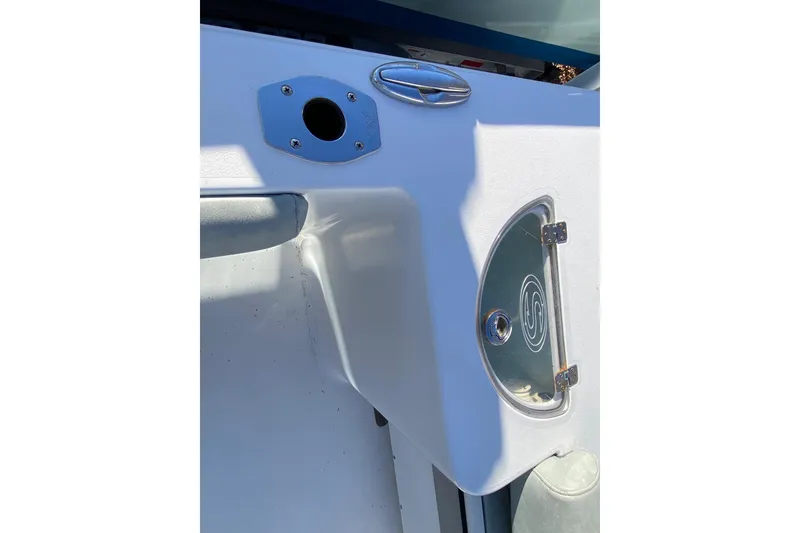 Slide: The Image of 2019 Sportsman Open 232 Center Console boat detail with storage compartment and rod holder. - 16