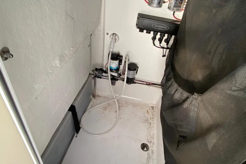 Slide: The Image of 2019 Sportsman Open 232 Center Console interior with Garmin electronics and plumbing components. - 18