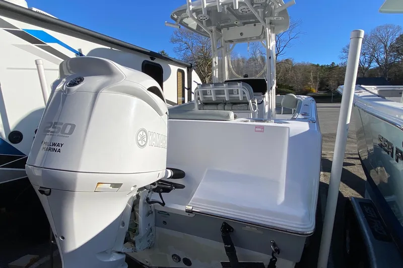 Slide: The Image of 2019 Sportsman Open 232 Center Console boat with Yamaha 250 engine, parked outdoors. - 2