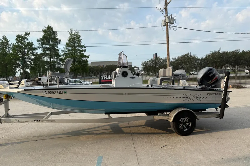 Slide: The Image of 2022 Xpress H20B Bay boat on trailer, parked outdoors, side view. - 5