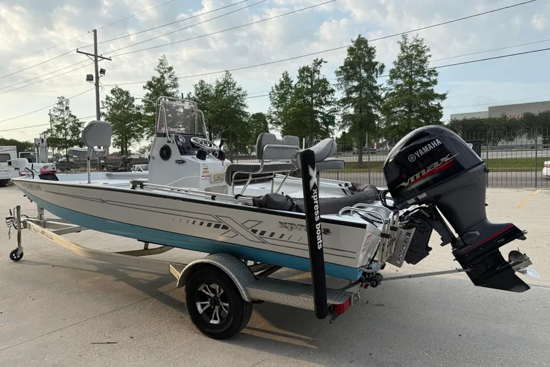 Slide: The Image of 2022 Xpress H20B Bay boat with Yamaha engine on trailer, parked outdoors. - 6