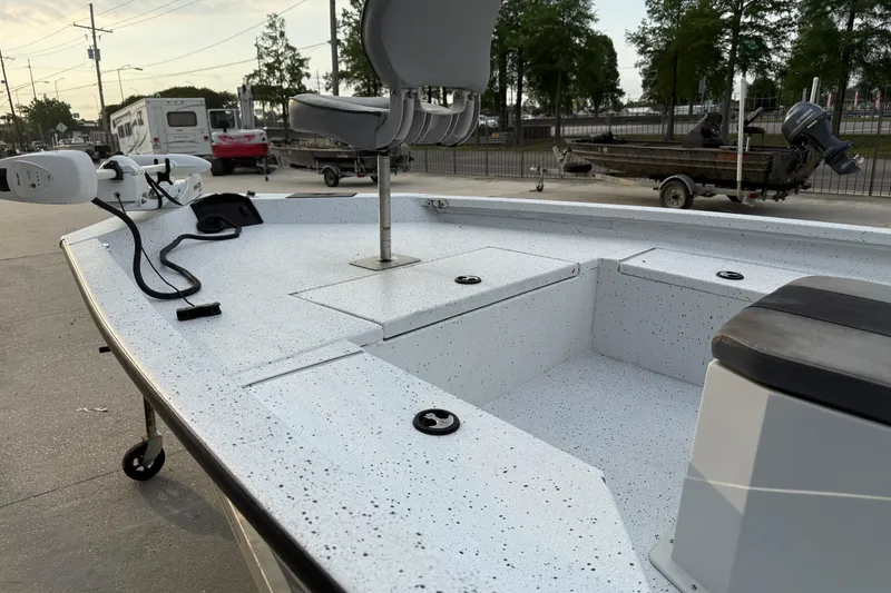 Slide: The Image of 2022 Xpress H20B Bay boat with speckled deck and seating, parked outdoors. - 8