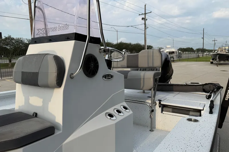 Slide: The Image of 2022 Xpress H20B Bay boat interior with seating and console, parked outdoors. - 9
