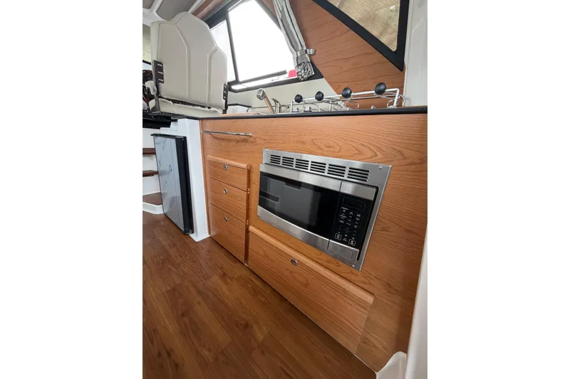 Slide: The Image of Interior of 2026 Cutwater C-288 CB boat with wood cabinetry and built-in microwave. - 15
