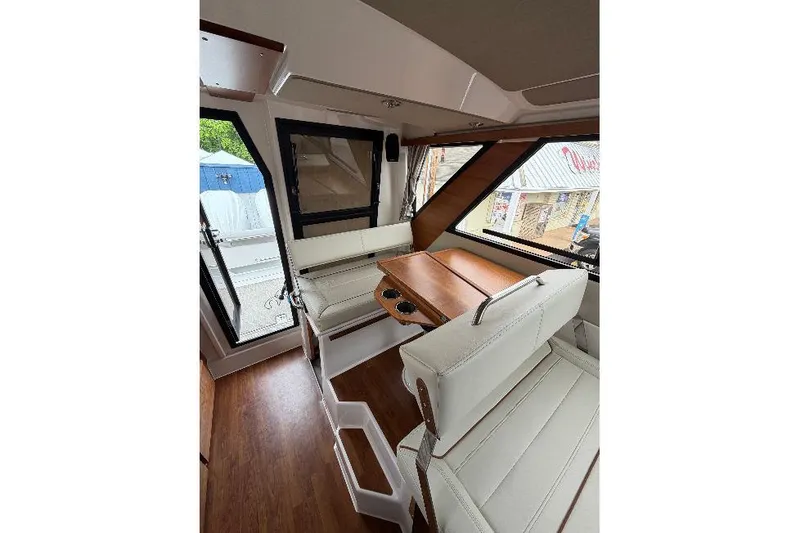 Slide: The Image of Interior of 2026 Cutwater C-288 CB boat with white seating and wooden table. - 17