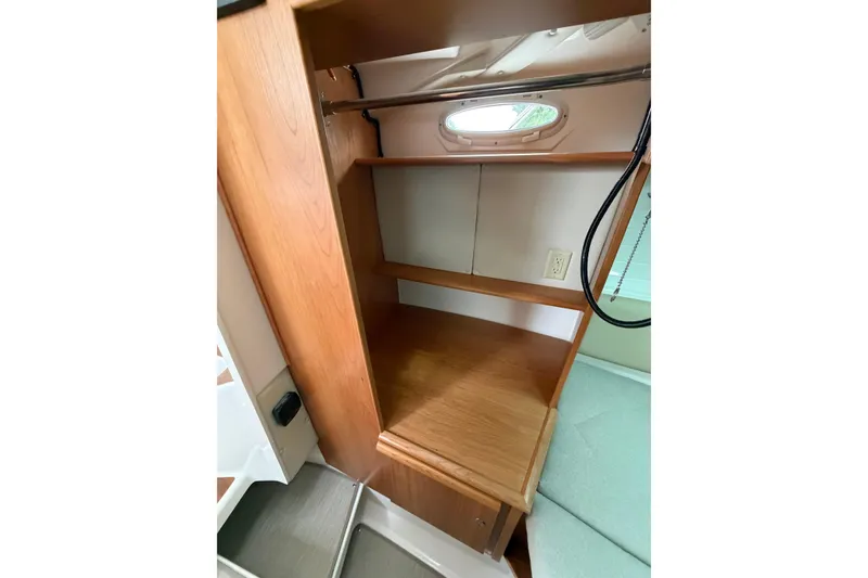 Slide: The Image of 2026 Cutwater C-288 CB interior wooden shelving with porthole and electrical outlet. - 18