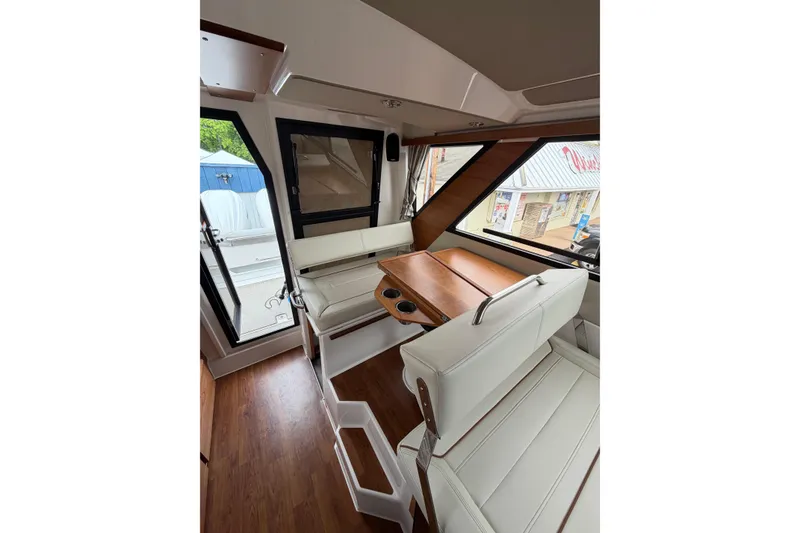 Slide: The Image of Interior of 2026 Cutwater C-288 CB boat with white seating and wooden table. - 22