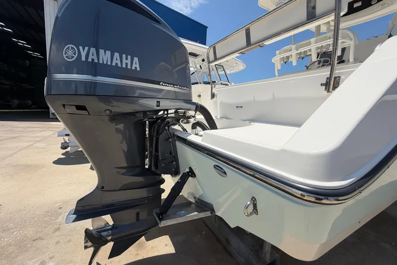 Slide: The Image of Century 2301 Center Console 2016 with Yamaha outboard motor in a sunny marina. - 10