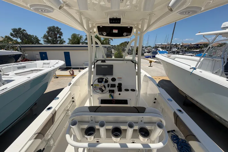 Slide: The Image of 2016 Century 2301 Center Console boat interior at marina, showcasing helm and seating. - 23