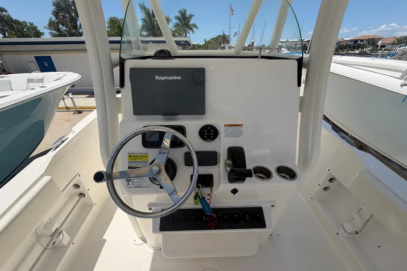 Slide: The Image of Century 2301 Center Console 2016 boat dashboard with steering wheel and Raymarine display. - 29