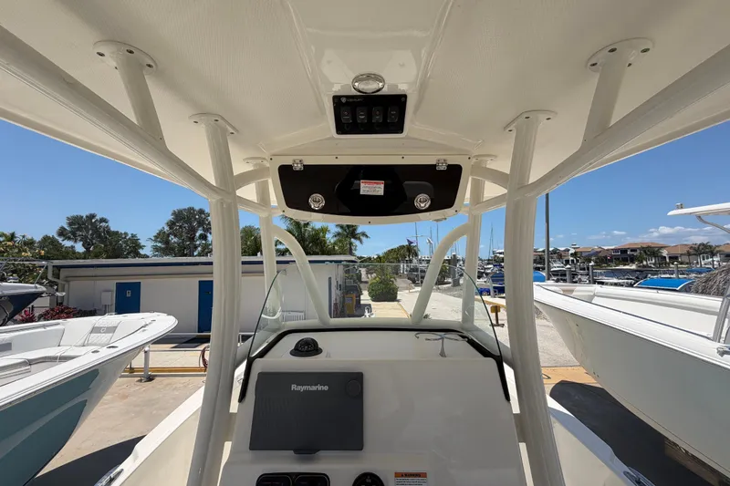 Slide: The Image of 2016 Century 2301 Center Console boat interior with Raymarine equipment, docked under clear skies. - 37