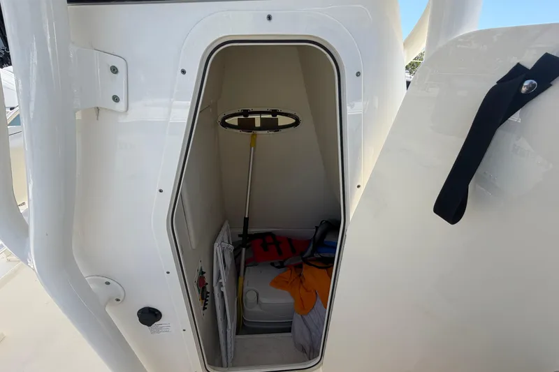 Slide: The Image of Storage compartment inside a 2016 Century 2301 Center Console boat, featuring safety equipment. - 43