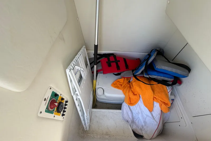 Slide: The Image of Storage compartment in a 2016 Century 2301 Center Console boat with life jackets and gear. - 44