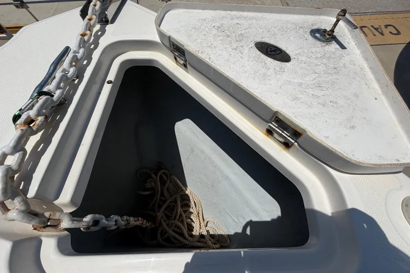 Slide: The Image of Open anchor locker on a 2016 Century 2301 Center Console boat, showing chain and rope. - 51