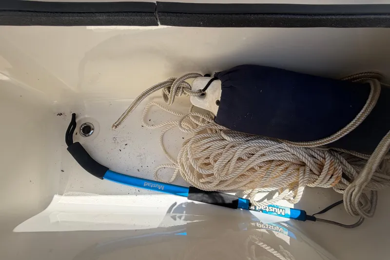 Slide: The Image of Storage compartment in a 2016 Century 2301 Center Console boat with rope and hook. - 57