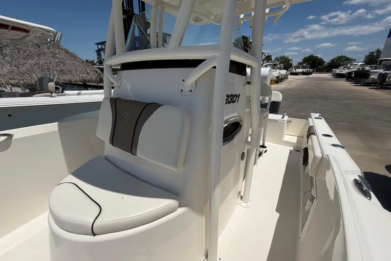 Slide: The Image of 2016 Century 2301 Center Console boat with seating, docked under a clear blue sky. - 60