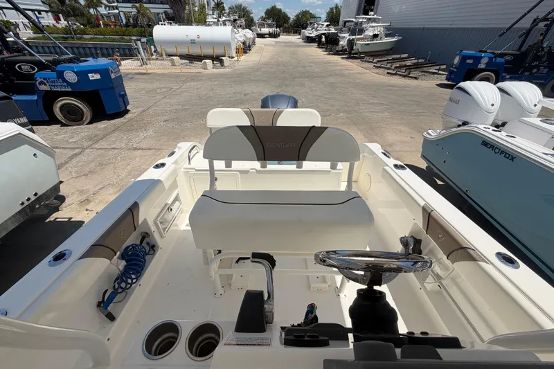 Slide: The Image of 2016 Century 2301 Center Console boat interior at a marina, showcasing seating and steering wheel. - 62