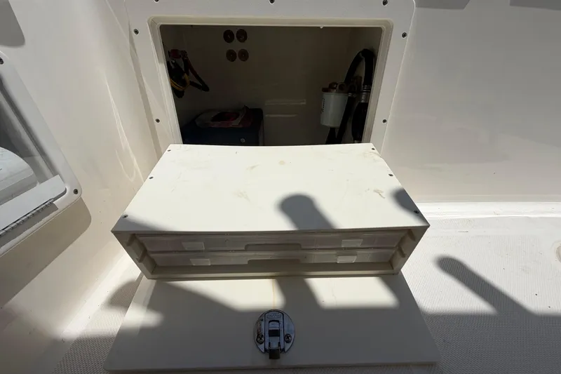 Slide: The Image of Storage compartment on a 2016 Century 2301 Center Console boat, open with visible equipment. - 73